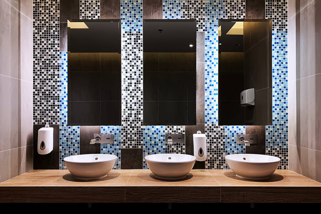 This front on image of the Commercial Bathroom in Lindfield Sydney NSW by Renovahouse shows just how important it is to have the right lighting in a luxury bathroom. These LED strip lights behind the mirrors make the mosaic tile patterns come to life.