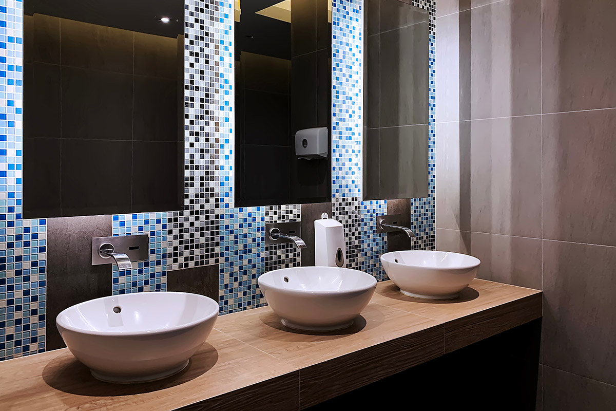 This photo of a Commercial Bathroom in Lindfield Sydney NSW by Renovahouse shows just how important it is to have the right lighting in a luxury bathroom. These LED strip lights behind the mirrors make the mosaic tile patterns come to life.