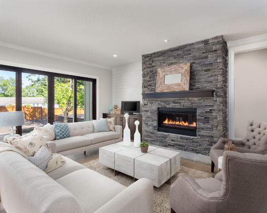 This complete interior design by Renovahouse in Sydney features a warm fireplace and stone feature in the middle of the living room.