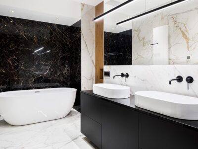 This luxury bathroom by Renovahouse in Sydney uses the beige vein in the marble walls and floor to match the timber feature panel in the wall